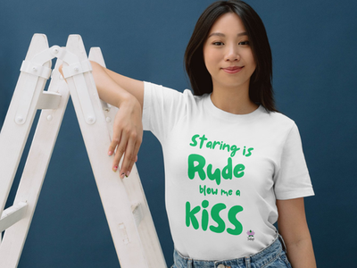 Person wearing a white T-shirt reading, "Staring is rude, blow me a kiss," promoting disability awareness.
